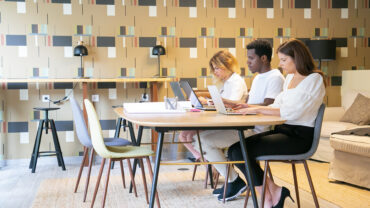 Team of focused designers sitting together at table